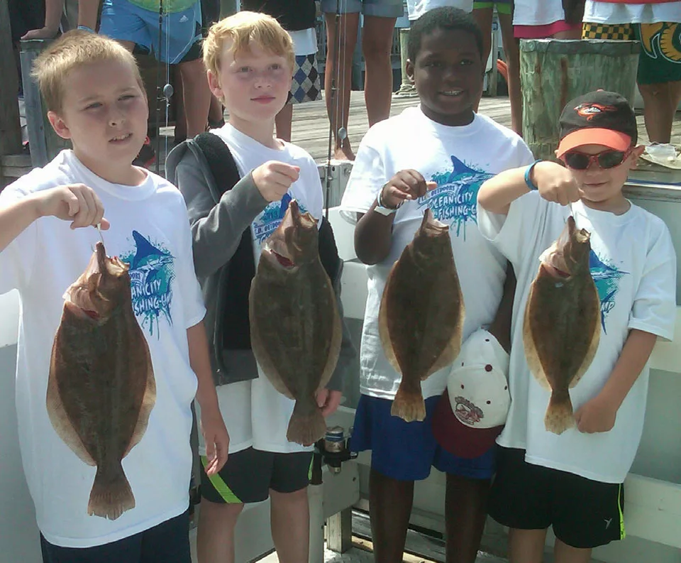 four boys holding caught fish